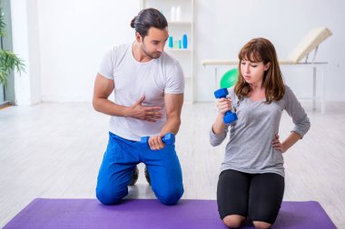 Kişisel koçla spor egzersizleri yapan genç bir kadın.