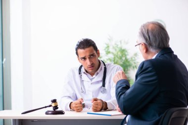 Adliyedeki erkek doktor avukatla toplantıda.