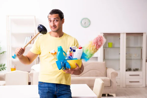 Jovem empreiteiro do sexo masculino fazendo trabalhos domésticos em casa — Fotografia de Stock