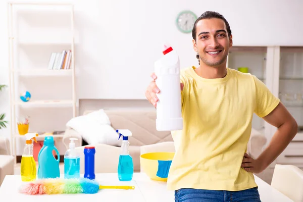Jovem empreiteiro do sexo masculino fazendo trabalhos domésticos em casa — Fotografia de Stock