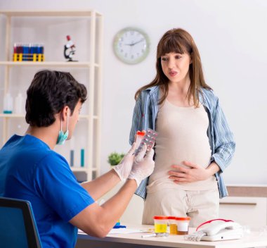Pregnant woman visiting doctor for check-up clipart