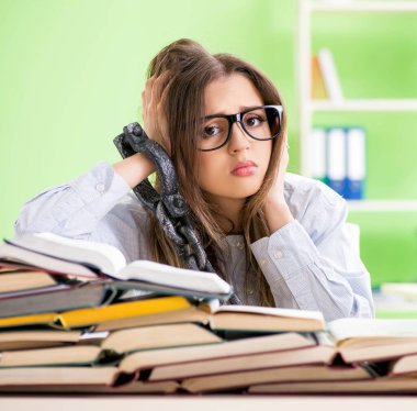 Genç kız öğrenci masaya zincirlendi ve sınavlara hazırlanıyor.