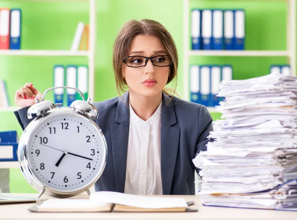 Jonge vrouwelijke werknemer zeer druk met lopende papierwerk in de tijd m — Stockfoto