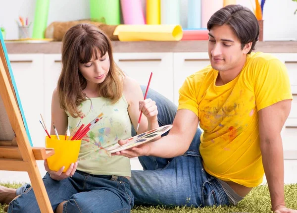 Pareja joven disfrutando de la pintura en casa — Foto de Stock