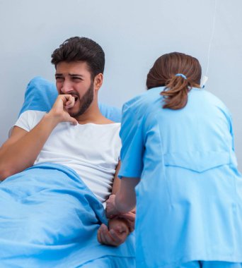 Kadın doktor erkek hastayı hastanede muayene ediyor.