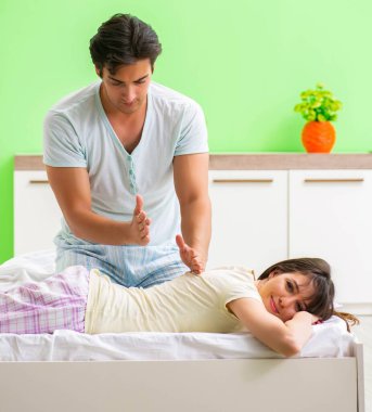 Adam yatak odasında karısına masaj yapıyor.