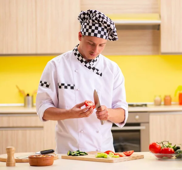 Joven cocinero profesional preparando ensalada en la cocina — Foto de Stock