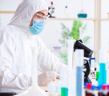 Laboratuvarda kimyasallar üzerinde çalışan genç bir kimyager.