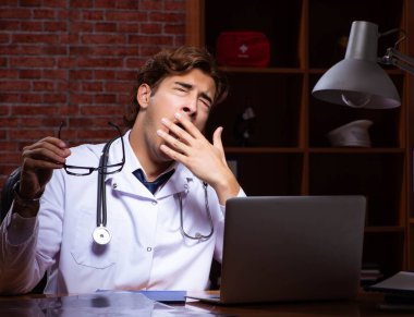 Genç yakışıklı doktor gece hastanede çalışıyor.