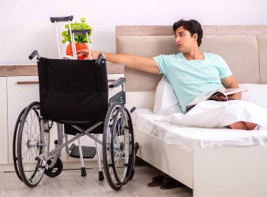 Genç yakışıklı engelli adam evde iyileşiyor.