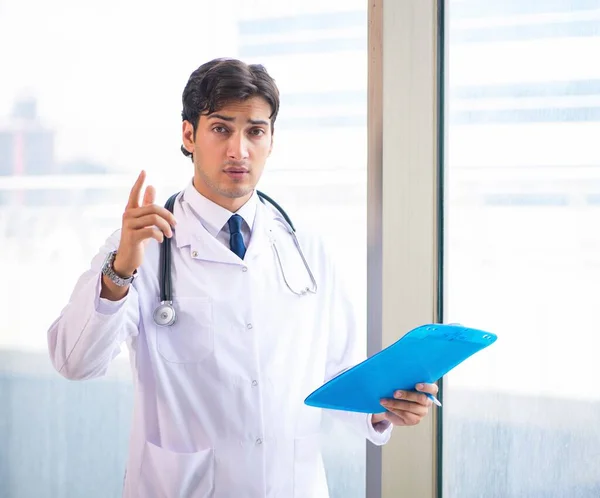 Jovem médico bonito em pé na janela — Fotografia de Stock