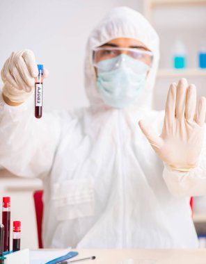 Genç yakışıklı laboratuvar asistanı hastanede kan örnekleri test ediyor.