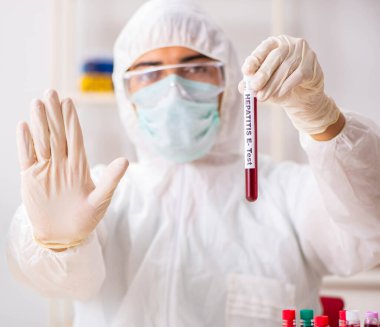 Genç yakışıklı laboratuvar asistanı hastanede kan örnekleri test ediyor.