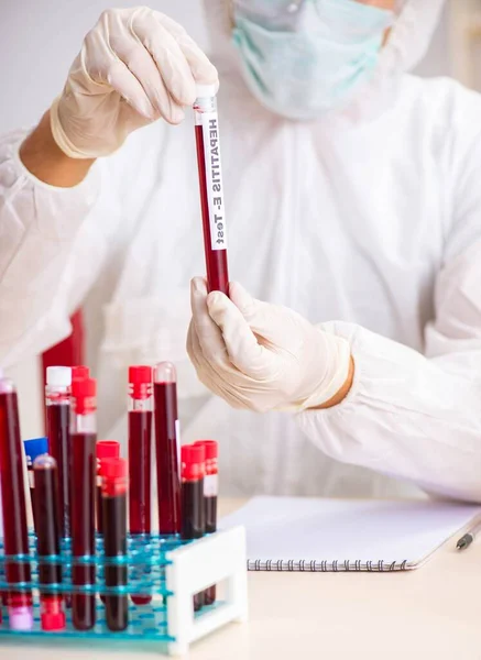 Asistente de laboratorio joven guapo analizando muestras de sangre en el hospital — Foto de Stock