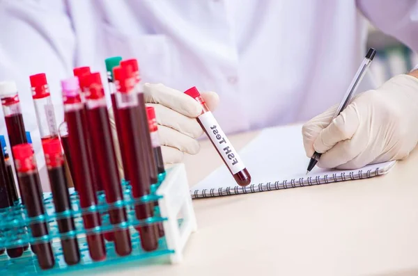 Asistente de laboratorio joven guapo analizando muestras de sangre en el hospital —  Fotos de Stock