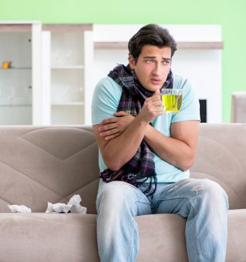 Evde hastalıktan muzdarip genç yakışıklı bir adam.