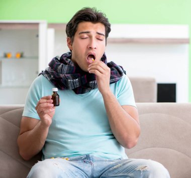 Evde hastalıktan muzdarip genç yakışıklı bir adam.