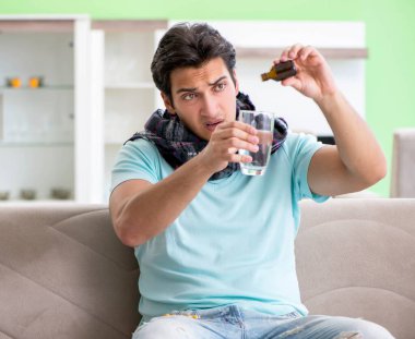 Evde hastalıktan muzdarip genç yakışıklı bir adam.