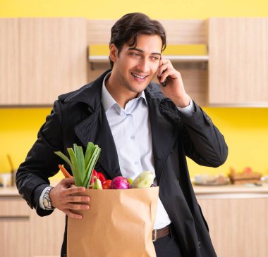 Mutfakta sebzeli genç yakışıklı adam.