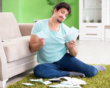 Genç adam kişisel finans ve faturalarla boğuşuyor.