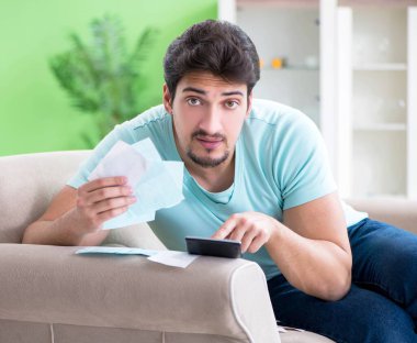 Genç adam kişisel finans ve faturalarla boğuşuyor.
