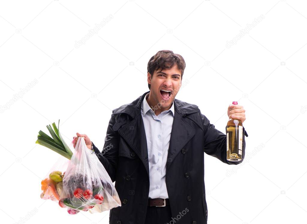 Young handsome man with vegatables in shopping concept