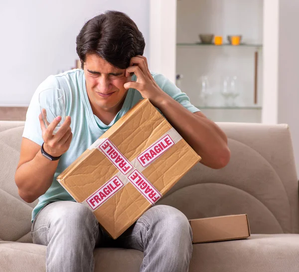 Hombre abriendo frágil paquete ordenado de internet — Foto de Stock