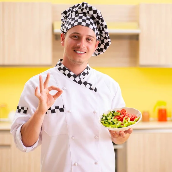 Jovem cozinheiro profissional preparando salada na cozinha — Fotografia de Stock