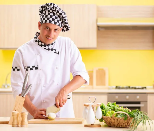 Joven cocinero profesional preparando ensalada en la cocina — Foto de Stock