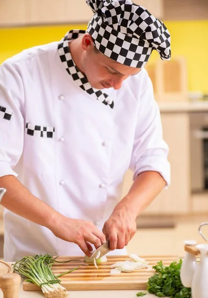 Young professional cook preparing salad at kitchen — Stock Photo, Image