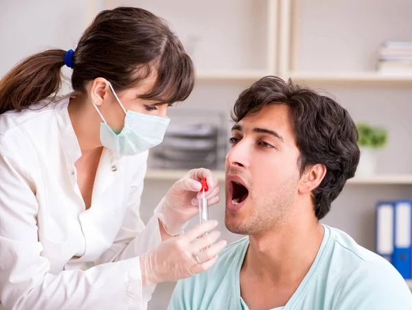 Jeune homme beau visitant le médecin dentiste féminin pour le retrait de — Photo