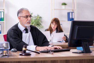 Yaşlı erkek yargıç ve genç sekreteri ofiste.