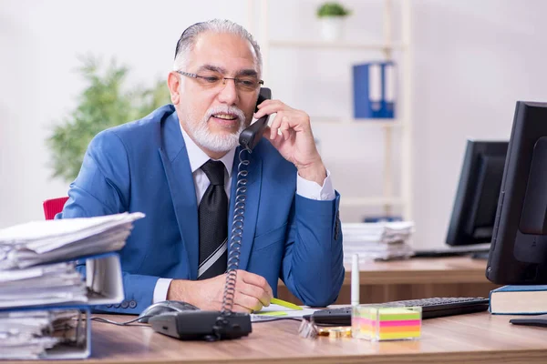 Old male employee and excessive work in the office — Stock Photo, Image