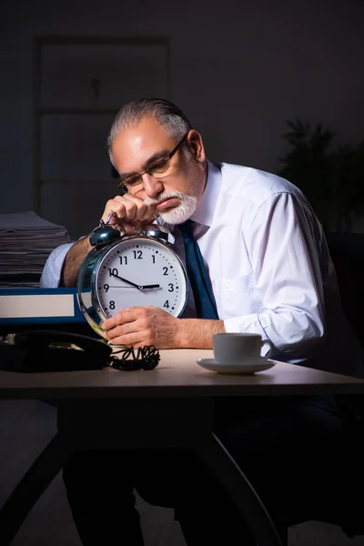 Vecchio dipendente maschile che lavora fino a tardi sul posto di lavoro — Foto Stock
