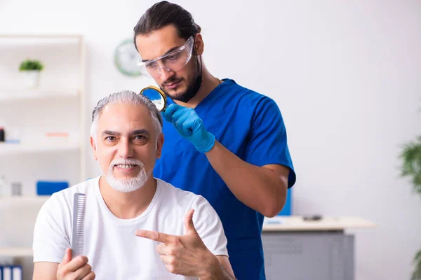 Old man visiting young male doctor in hair transplantation conce — Stock Photo, Image