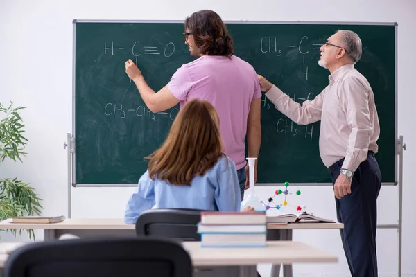 老化学老师和两个学生在教室里 — 图库照片