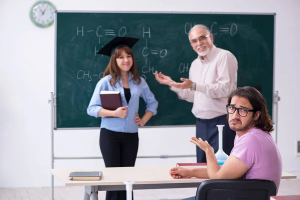 Oude scheikundeleraar en twee leerlingen in de klas — Stockfoto