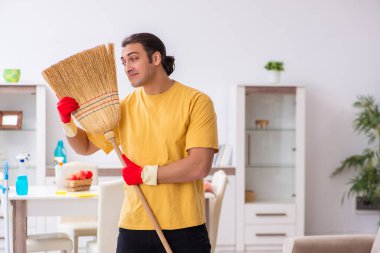 Genç erkek müteahhit evi temizliyor.