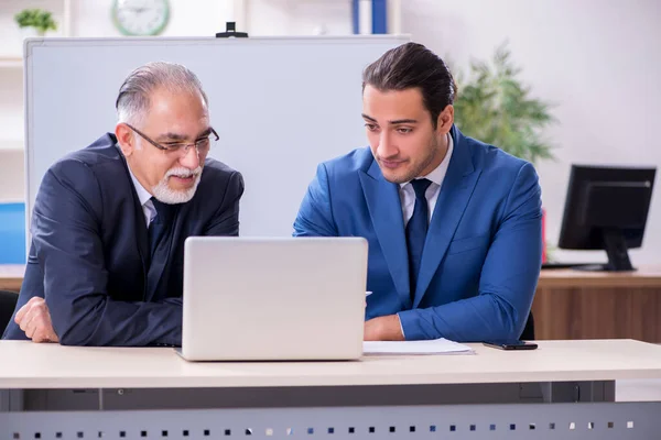 Junge und alte Mitarbeiter im Präsentationskonzept — Stockfoto