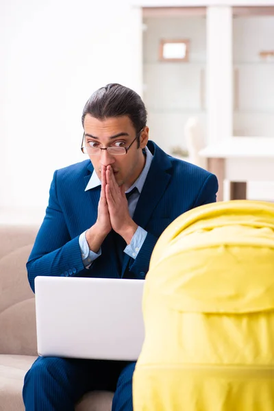 Young businessman looking after newborn at home