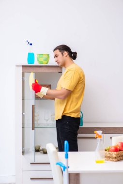 Genç erkek müteahhit evi temizliyor.