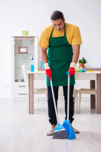 Jovem empreiteiro limpando a casa — Fotografia de Stock