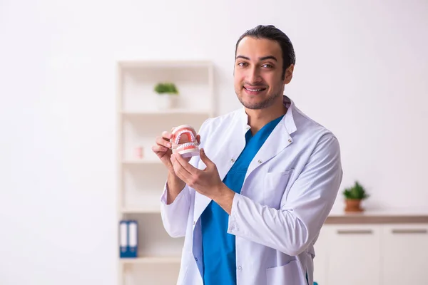 Jonge mannelijke tandarts werkzaam in de kliniek — Stockfoto