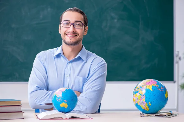 Ung manlig geografi lärare framför svarta tavlan — Stockfoto