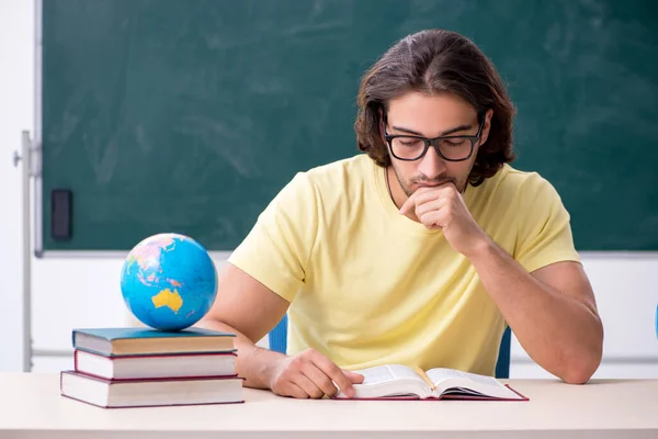 Joven profesor de geografía masculina frente a la pizarra —  Fotos de Stock