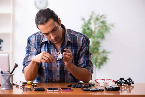 Jovem técnico do sexo masculino reparando telefone celular — Fotografia de Stock