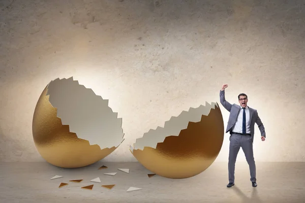 Businessman breaking out of golden egg — Stock Photo, Image