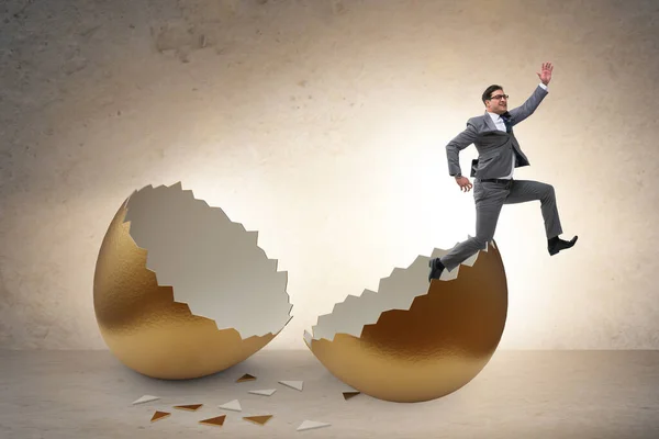 Businessman breaking out of golden egg — Stock Photo, Image