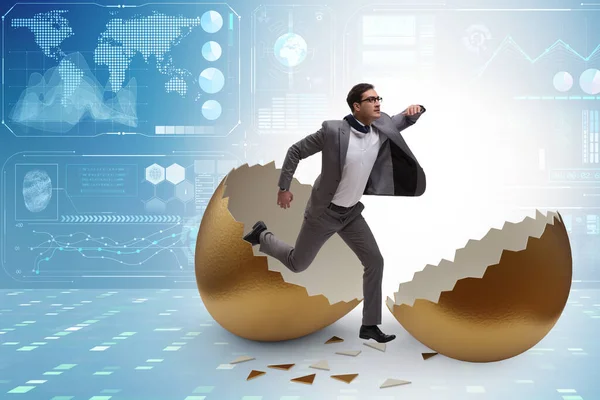 Businessman breaking out of golden egg — Stock Photo, Image