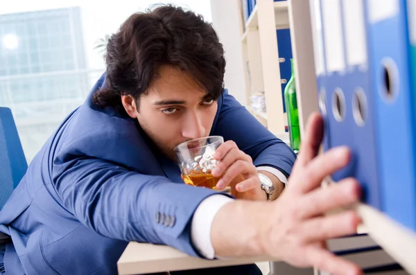 Young businessman employee drinking in the office — Stock Photo, Image